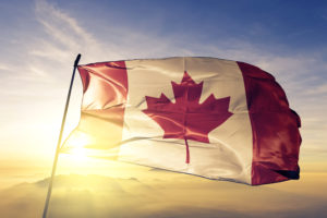 Canada Canadian flag on flagpole textile cloth fabric waving on the top sunrise mist fog